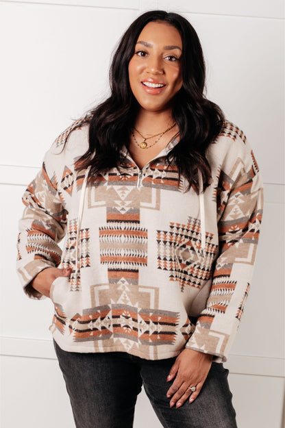 Woman wearing a patterned hoodie against a white background