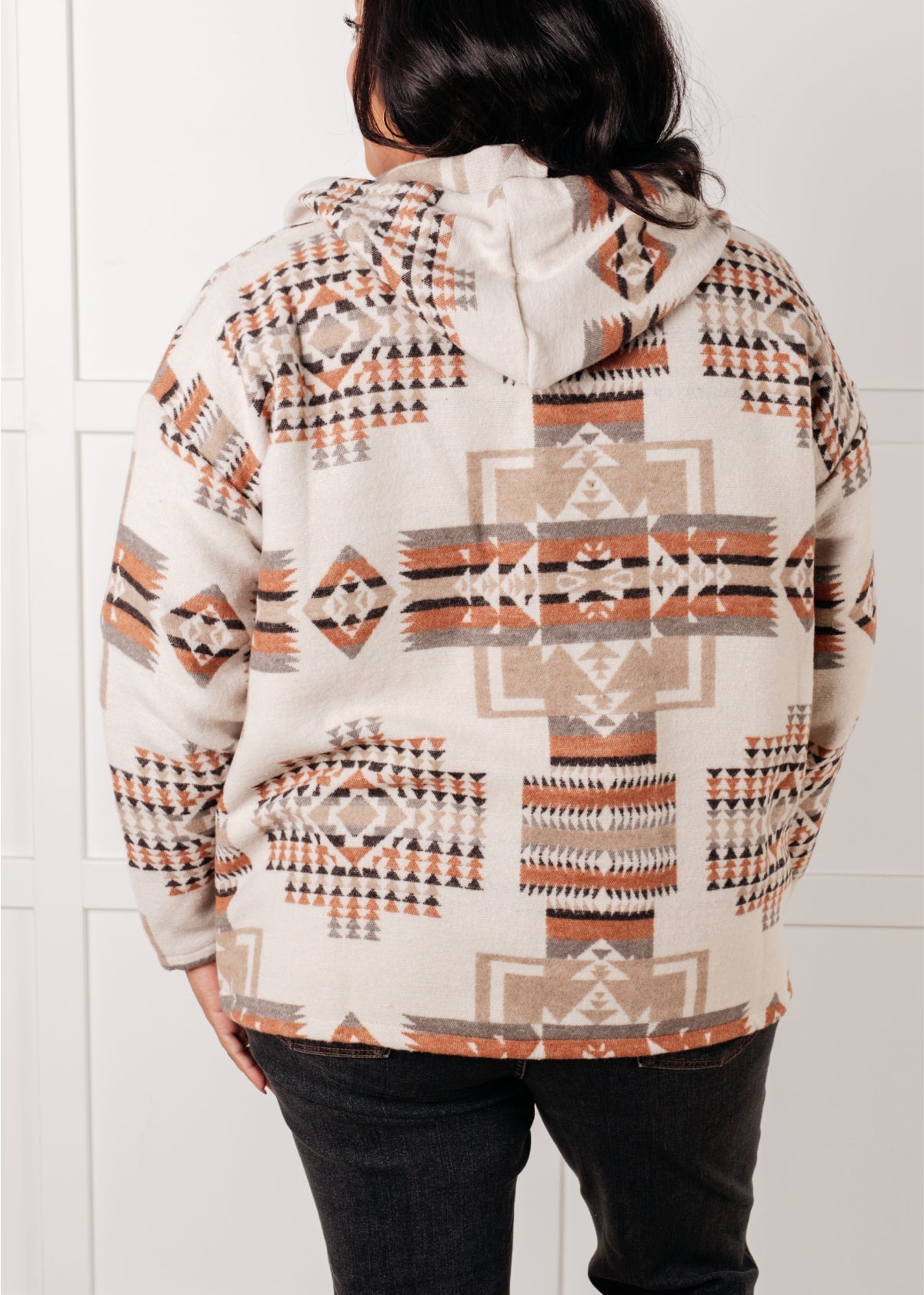 Person wearing a patterned hoodie with a white background