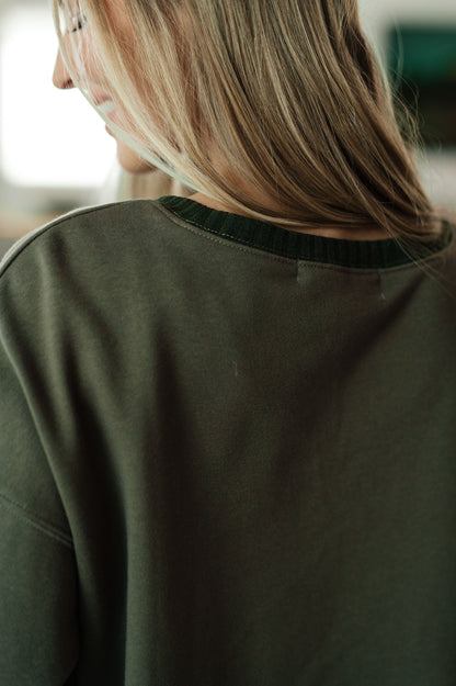Person wearing a green shirt with a blurred background