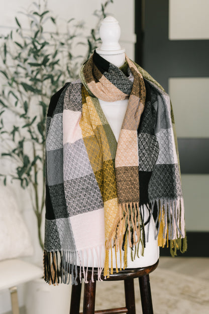 Plaid scarf with fringe on a mannequin against a neutral background