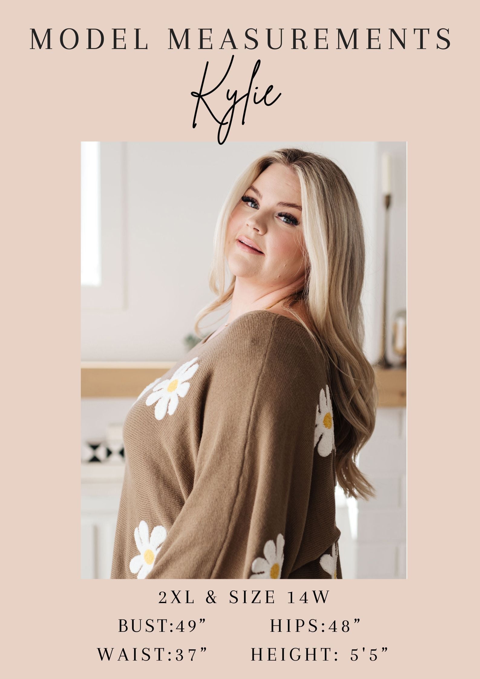 Woman wearing a brown cardigan with white floral patterns, standing in a kitchen.