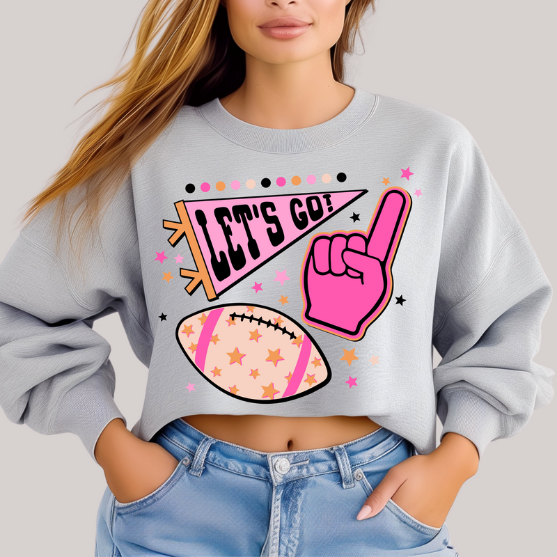 Person wearing a light gray sweatshirt with sports-themed graphics and text.