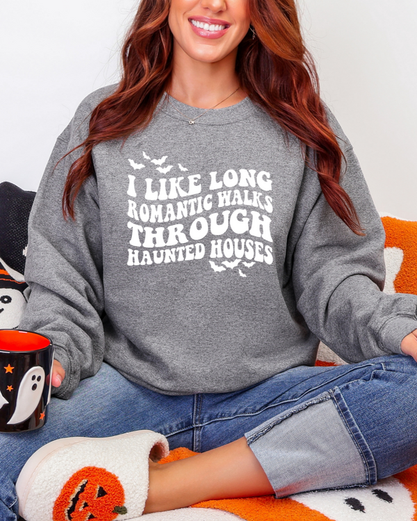 Person wearing a Halloween-themed sweatshirt with text, sitting on a festive blanket.