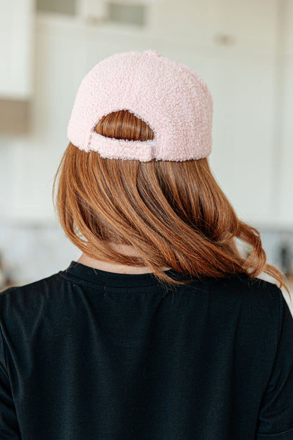 Person wearing a pink fuzzy beanie from behind in an indoor setting