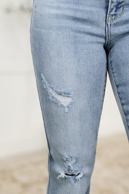 Close-up of light blue jeans with distressing details on a blurred background