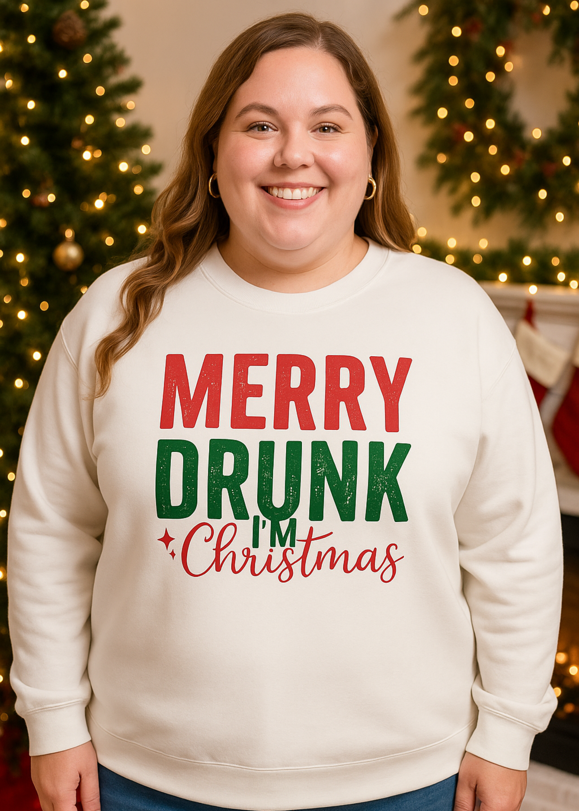 Person wearing a cream sweatshirt with 'Merry Drunk Christmas' text in front of a decorated Christmas tree.