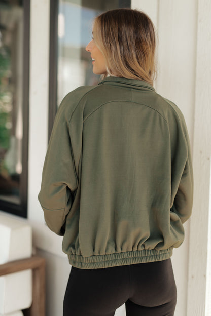 Person wearing an olive green jacket indoors