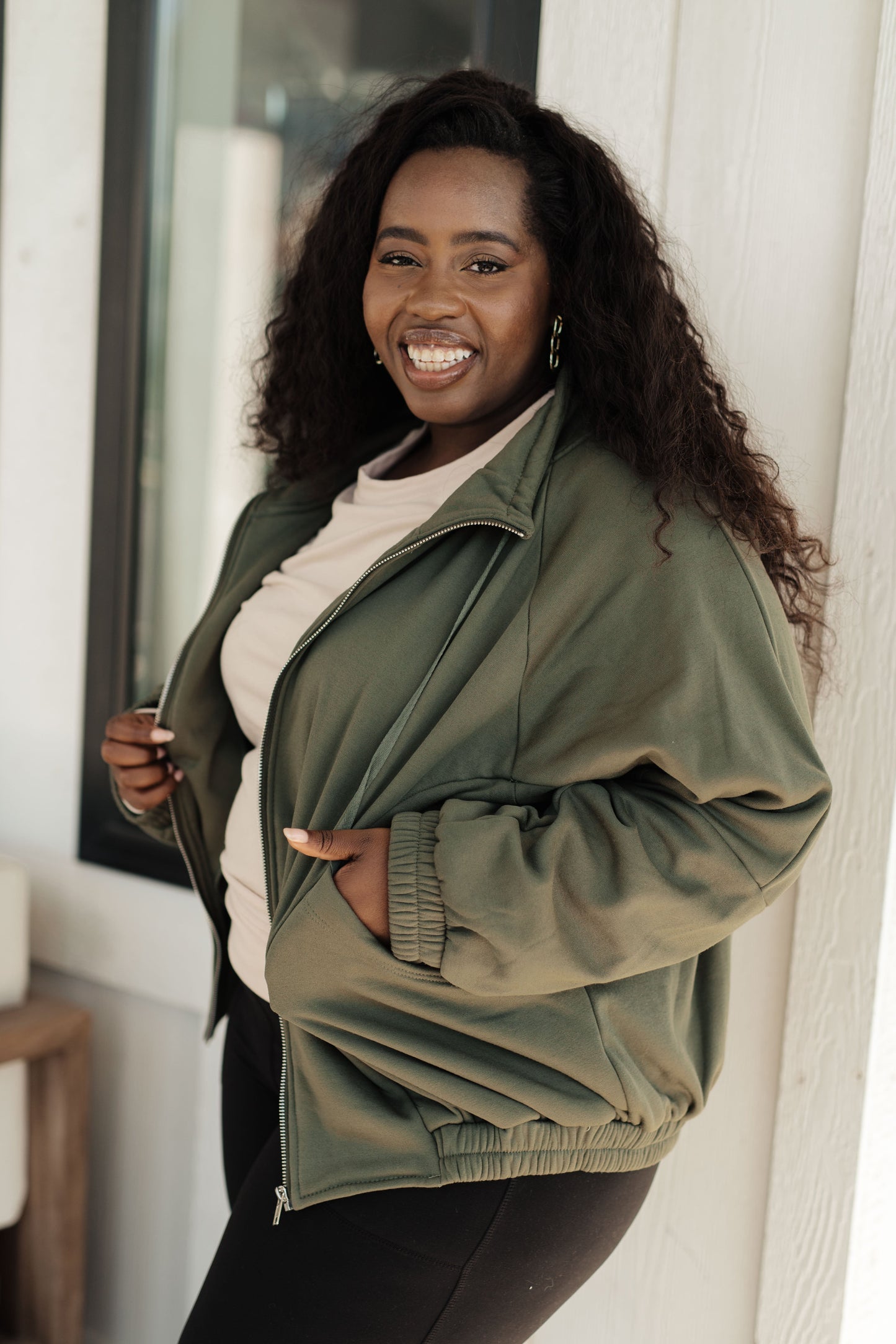 Woman wearing a green jacket standing indoors