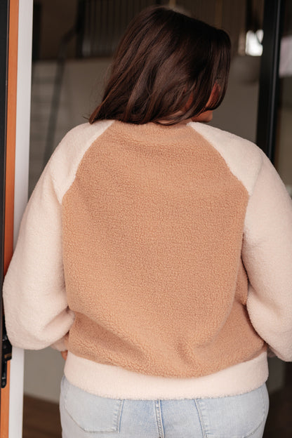 Person wearing a beige and white sweater with a textured pattern.