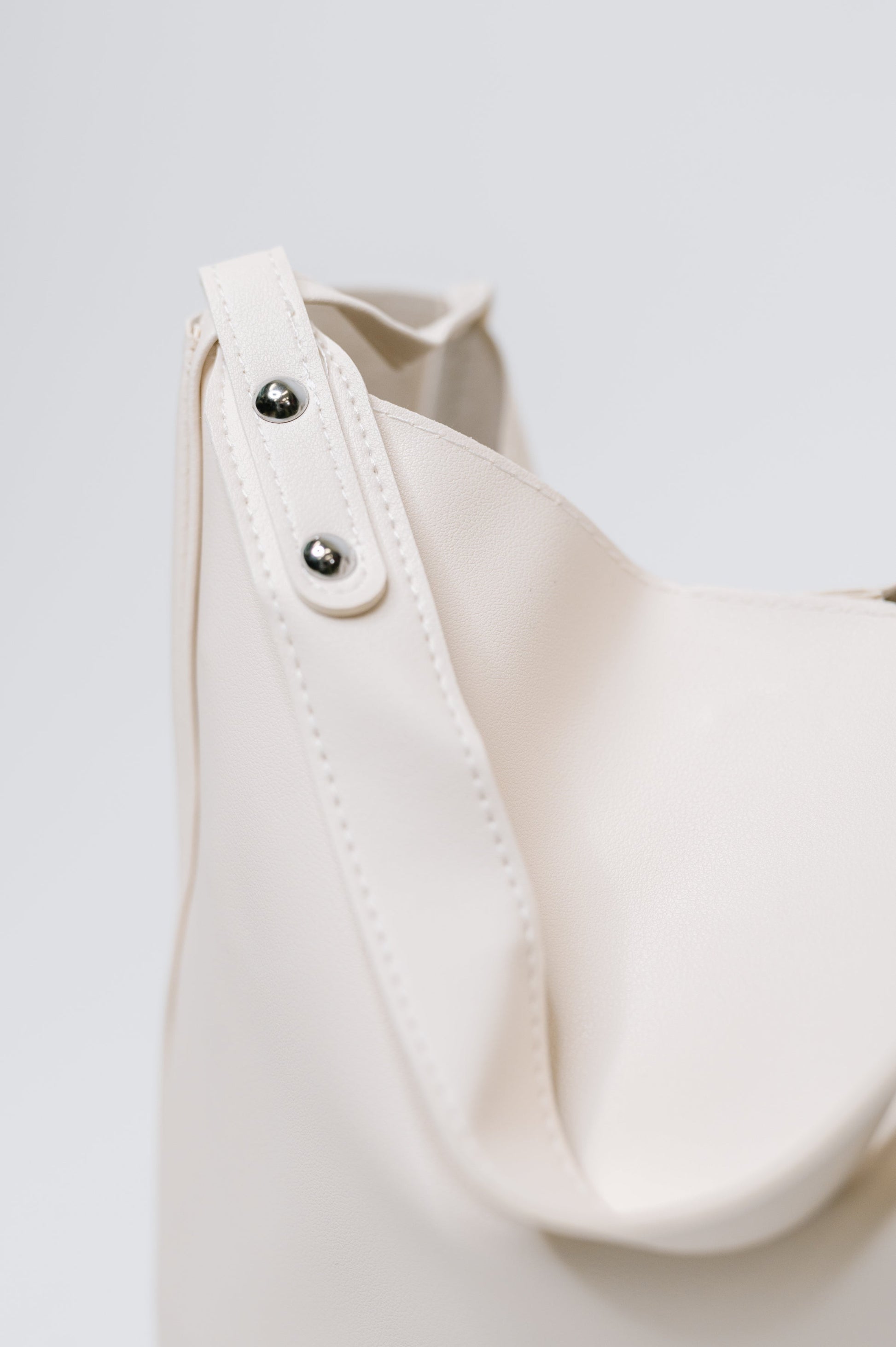Close-up of a white garment with buttons on a light gray background