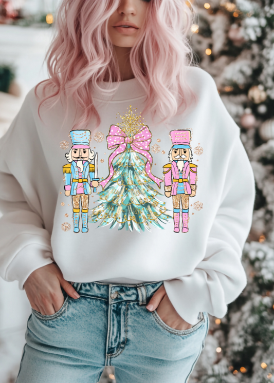 Person wearing a white sweatshirt with Christmas-themed design in front of a decorated tree.