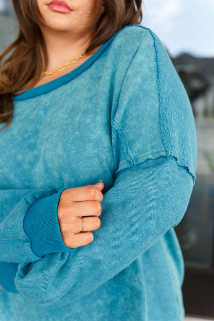 Close-up of a person wearing a blue sweater with a blurred background