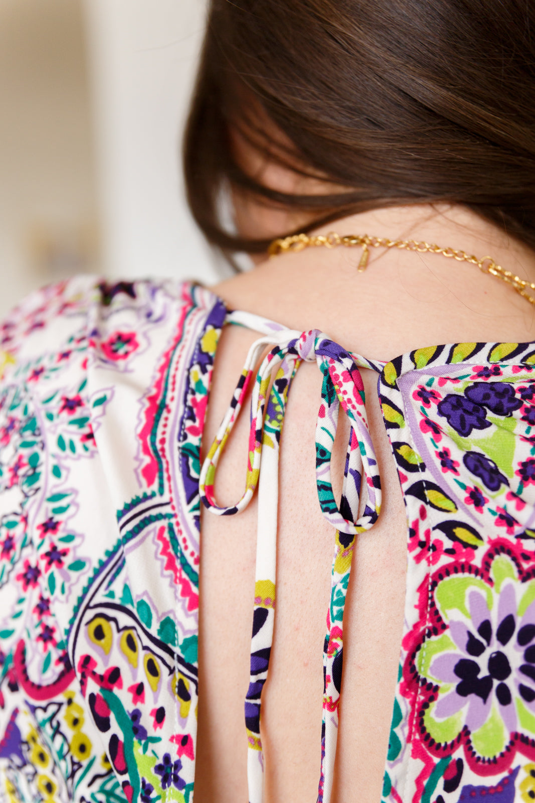 Colorful floral-patterned top with cut-out design on a blurred background