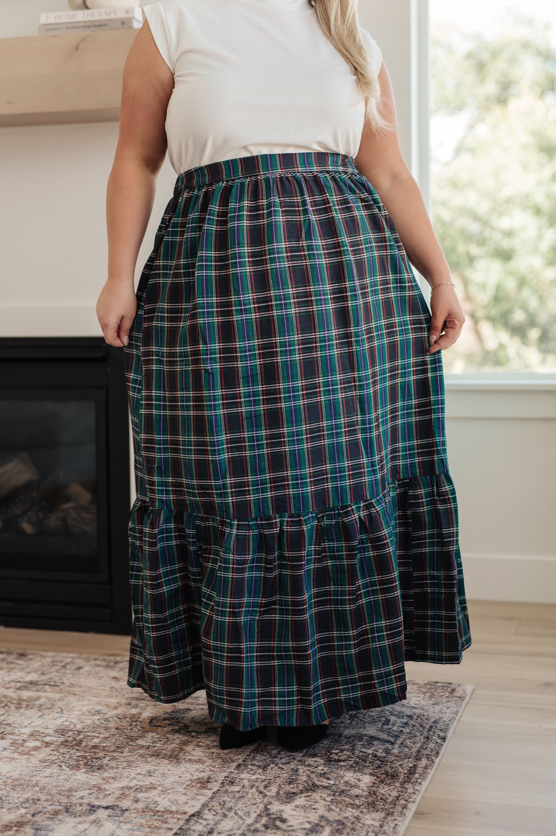 Person wearing a plaid skirt in a home setting