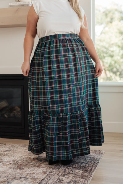 Person wearing a plaid skirt in a home setting
