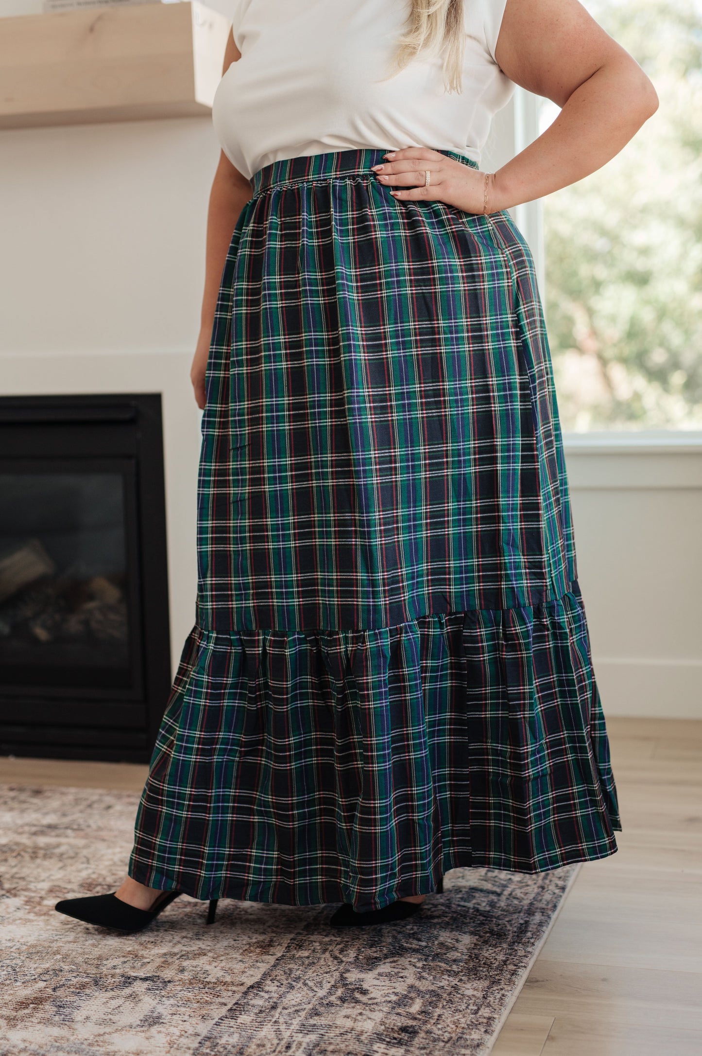 Person wearing a plaid skirt in a home setting