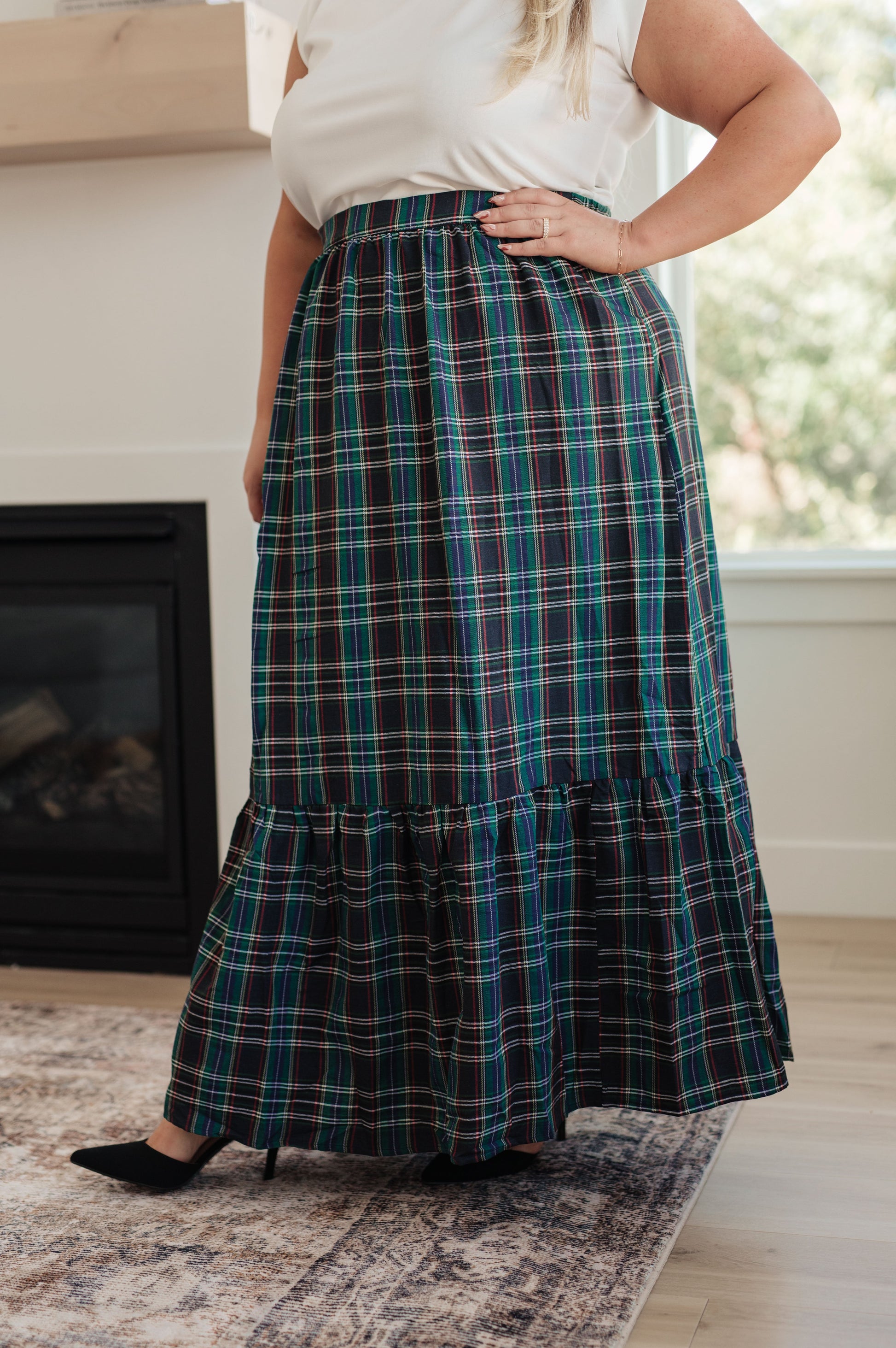 Person wearing a plaid skirt in a home setting