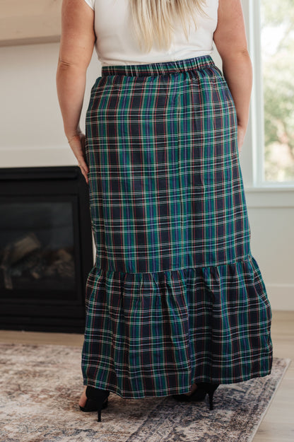 Person wearing a plaid skirt in a home setting
