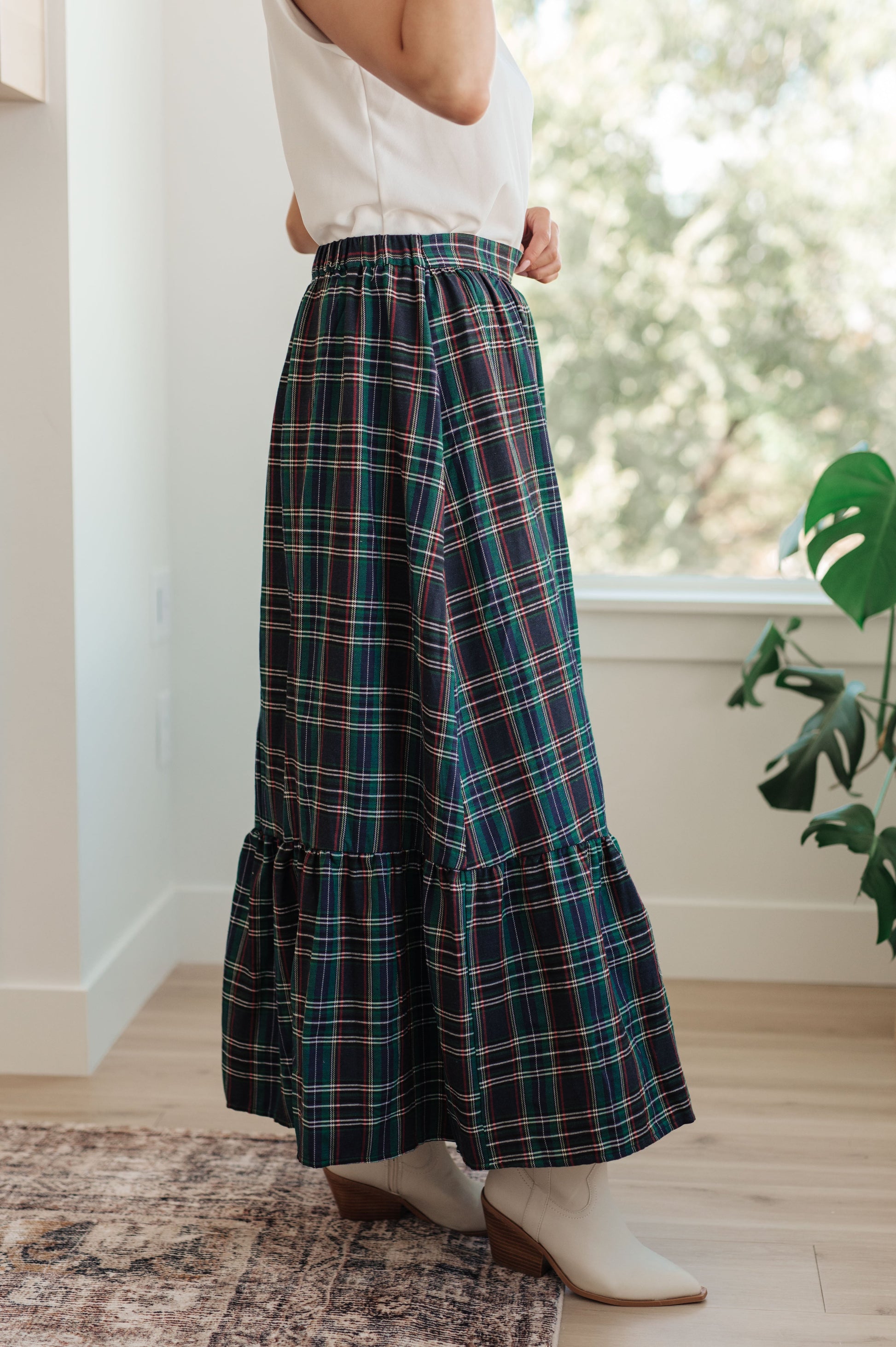 Person wearing a plaid skirt in a home setting