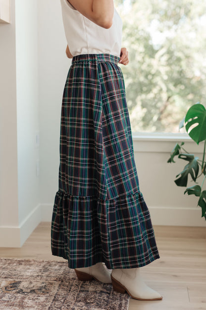 Person wearing a plaid skirt in a home setting