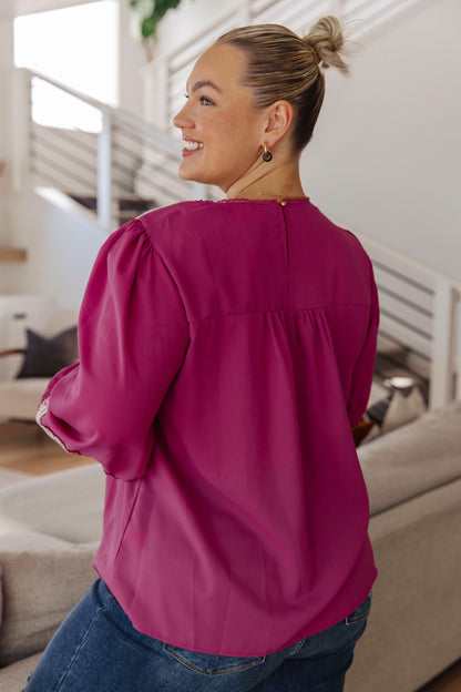 Woman wearing a bright pink blouse in a home setting