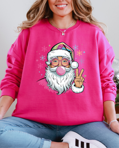 Person wearing a pink sweatshirt with a cartoon Santa Claus design, sitting indoors.