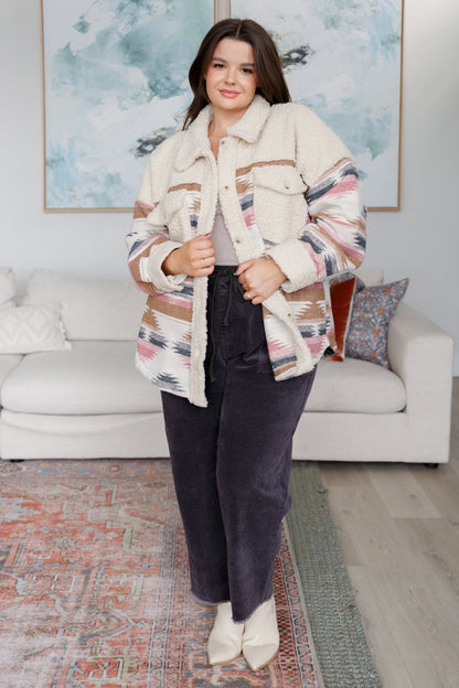 Woman wearing a patterned jacket in a living room setting