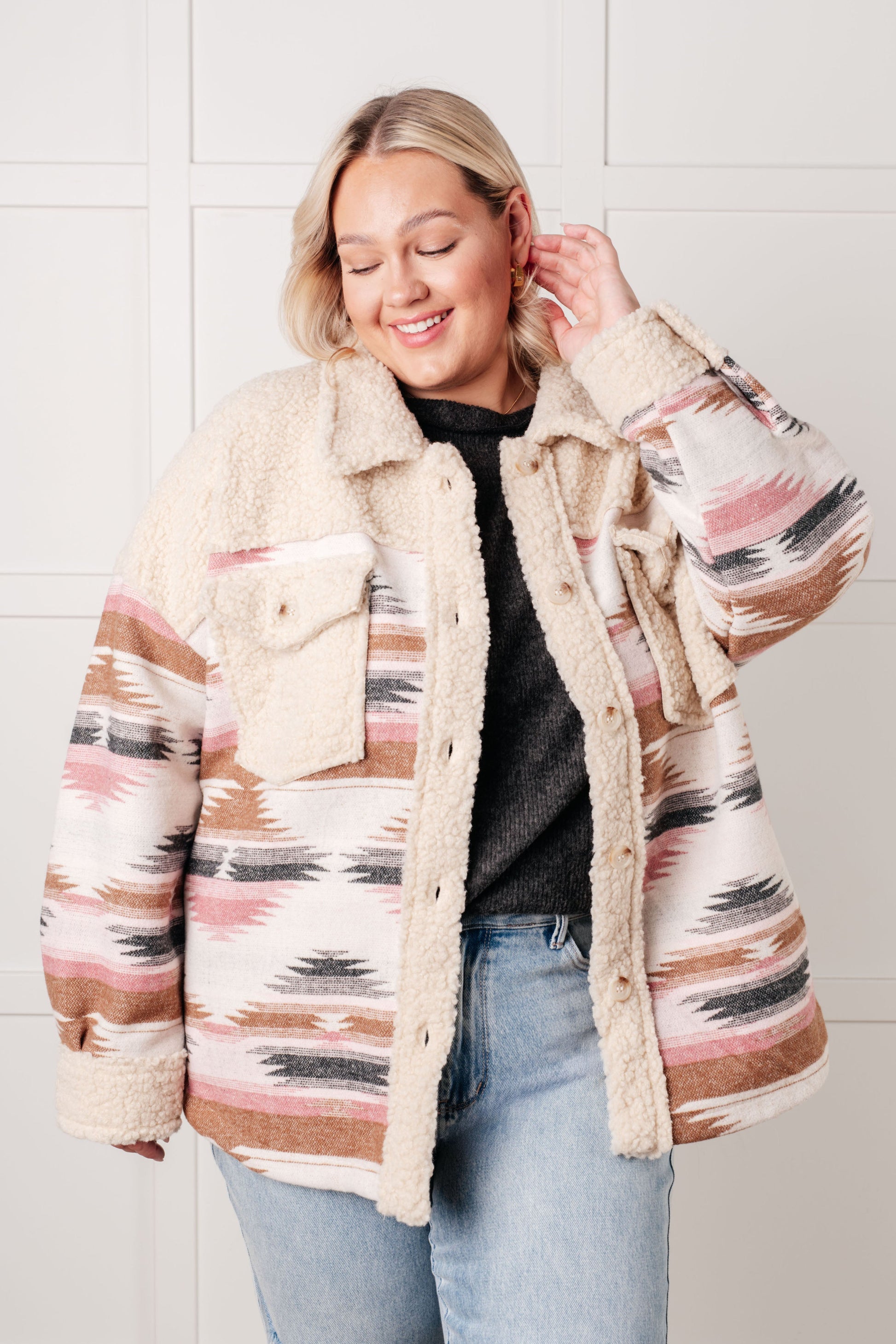 Woman wearing a patterned jacket with a white background