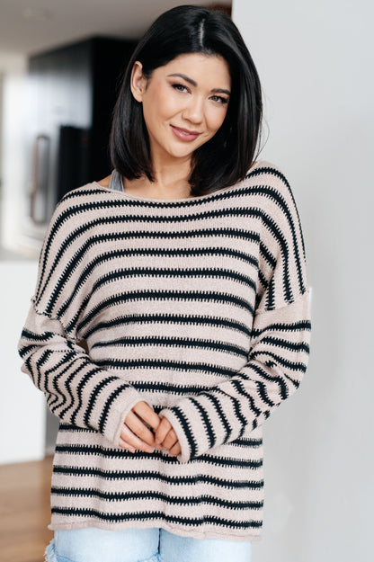 Woman wearing a black and white striped sweater indoors.