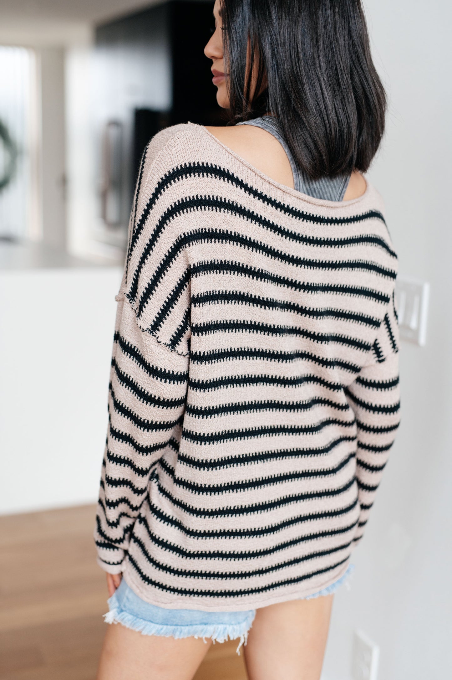 Person wearing a black and white striped sweater with a blurred background