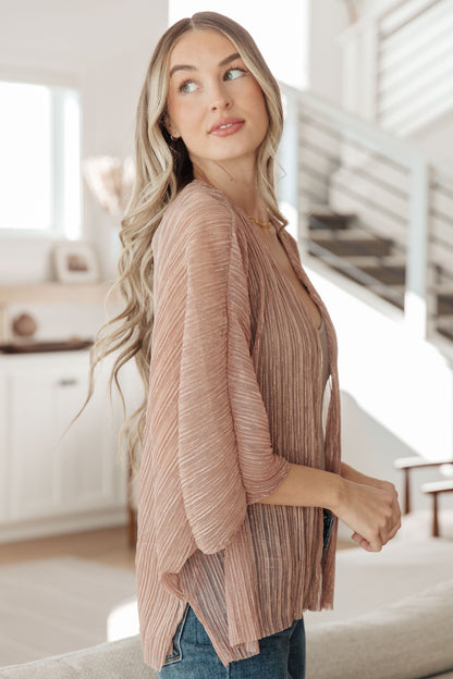 Woman wearing a pink ribbed sweater in a kitchen setting