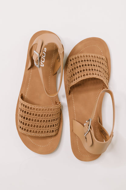 Pair of tan sandals with woven design on a white background