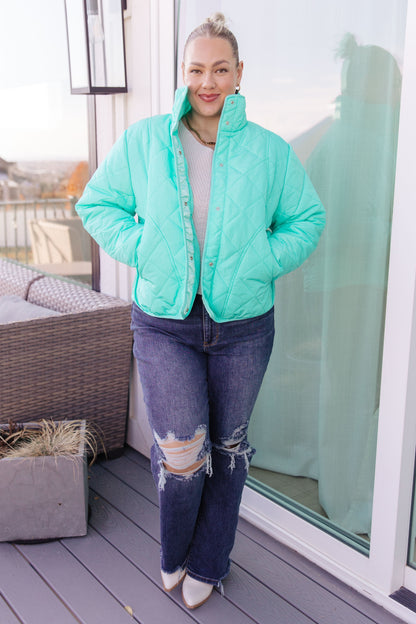 Person wearing a light blue puffer jacket on a balcony