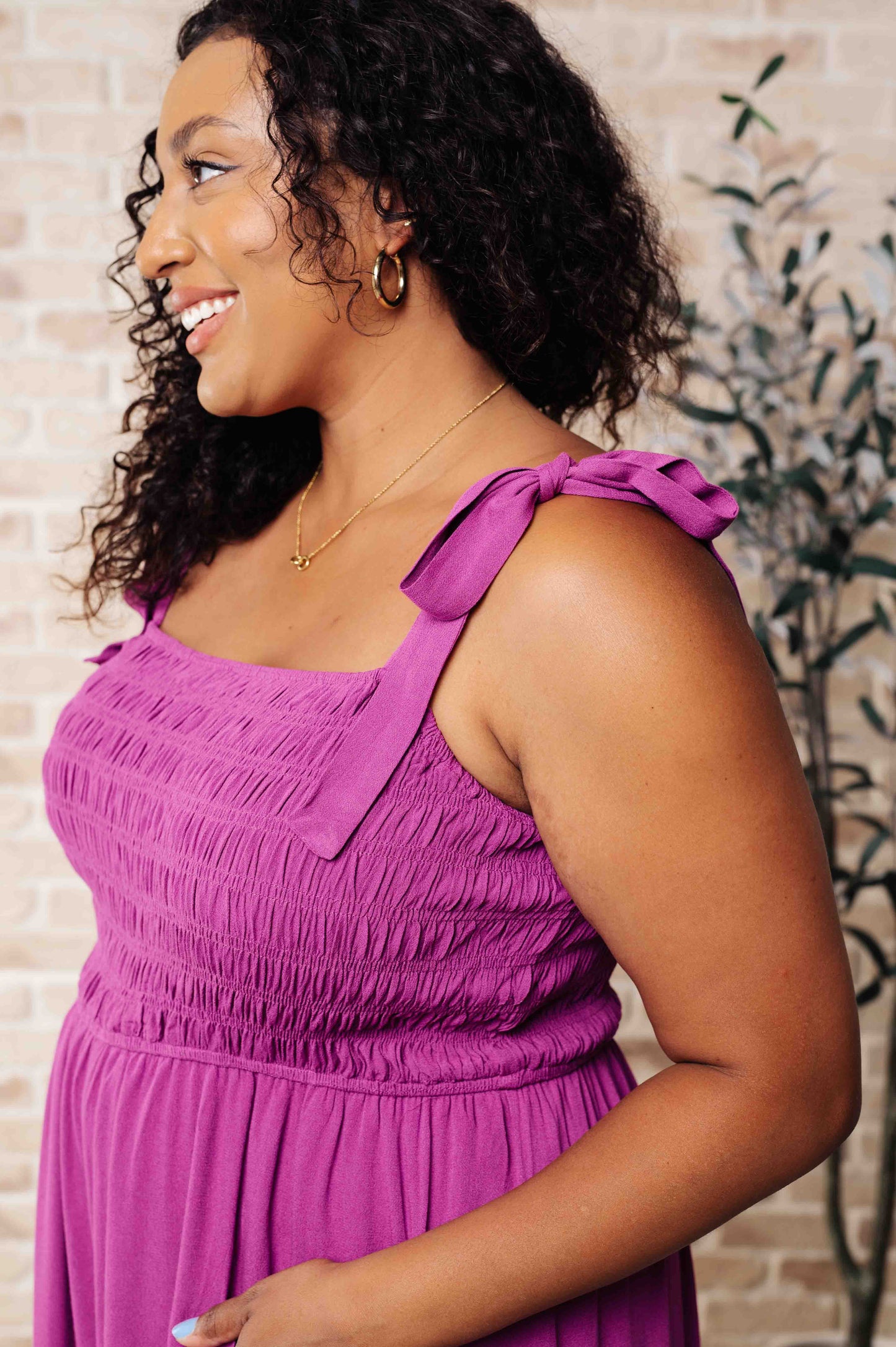Woman wearing a purple dress with a textured wall background