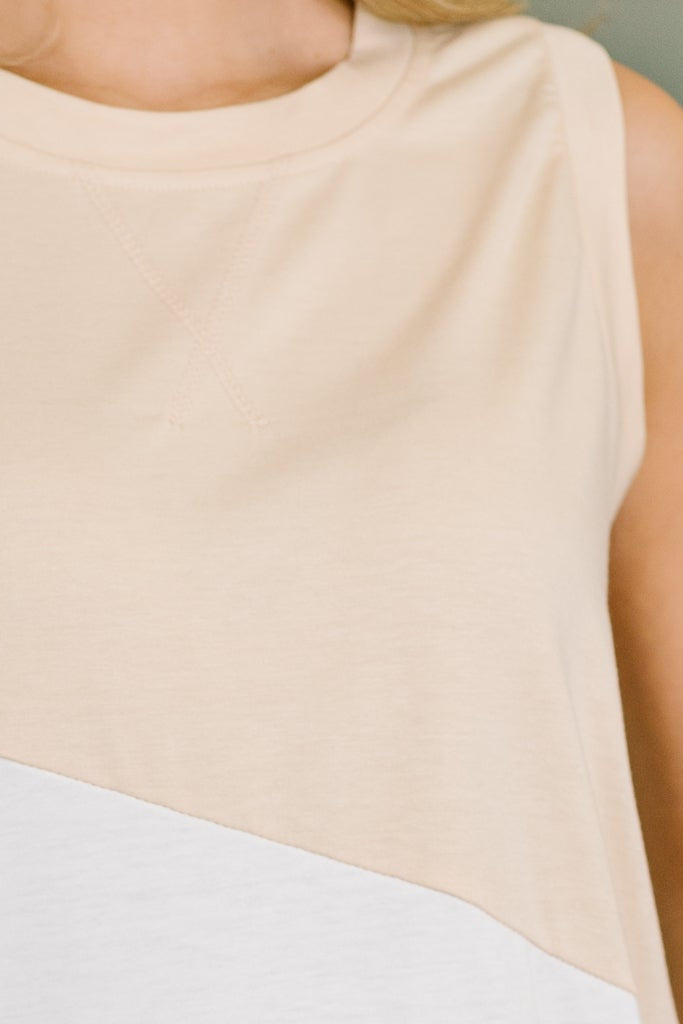 Close-up of a beige sleeveless top worn by a person.