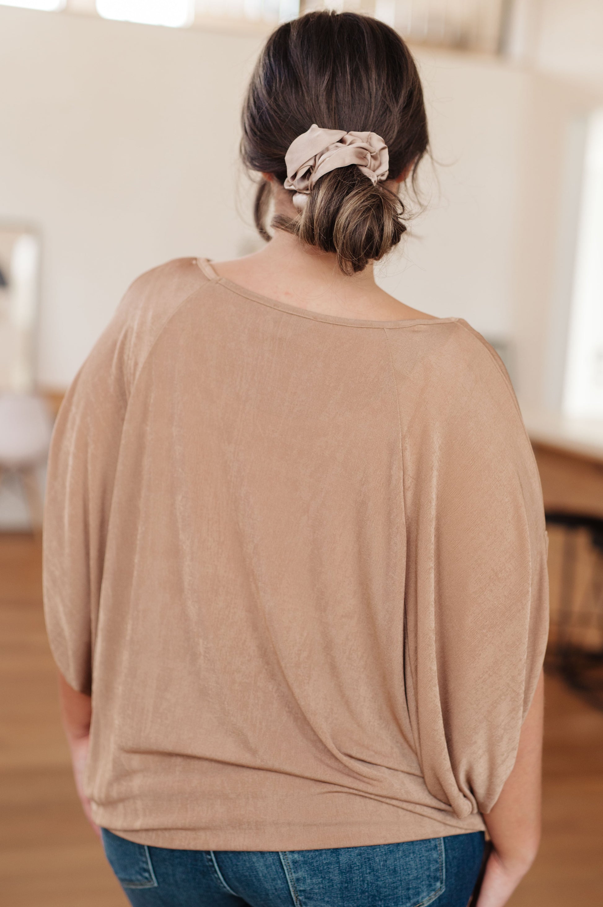 Person wearing a beige top with a blurred background