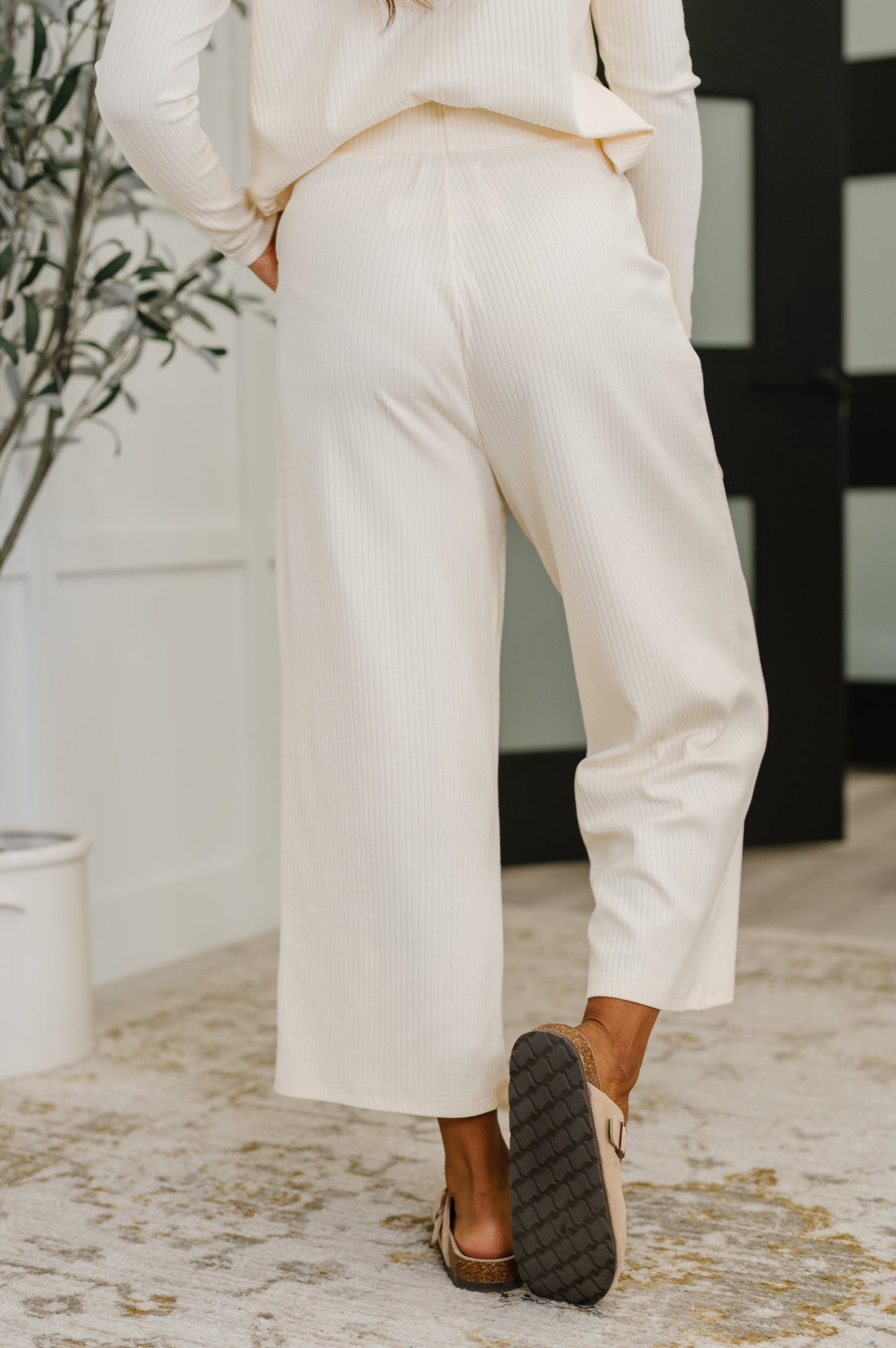 Person wearing white pants and brown shoes indoors