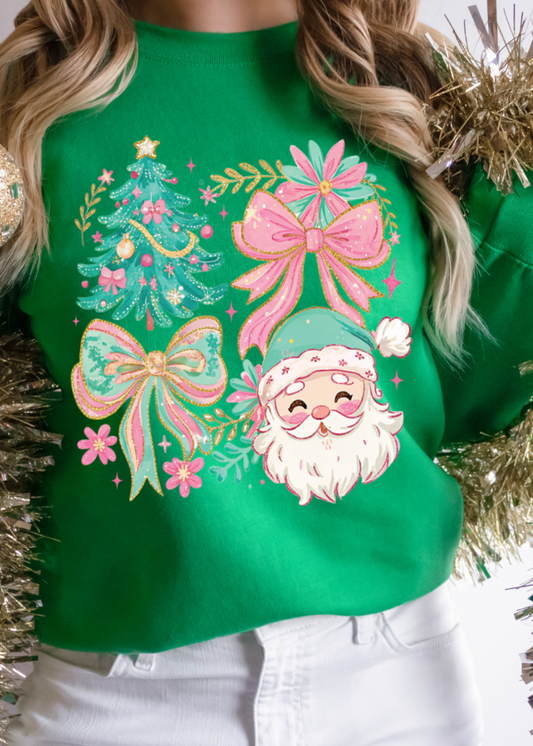 Green sweater with festive design featuring Santa Claus, trees, and bows, held by a person surrounded by gold tinsel.