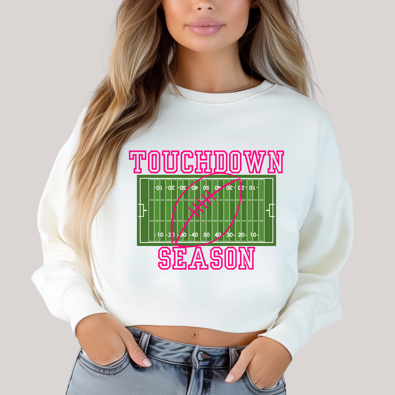 Person wearing a white sweatshirt with 'Touchdown Season' graphic design.