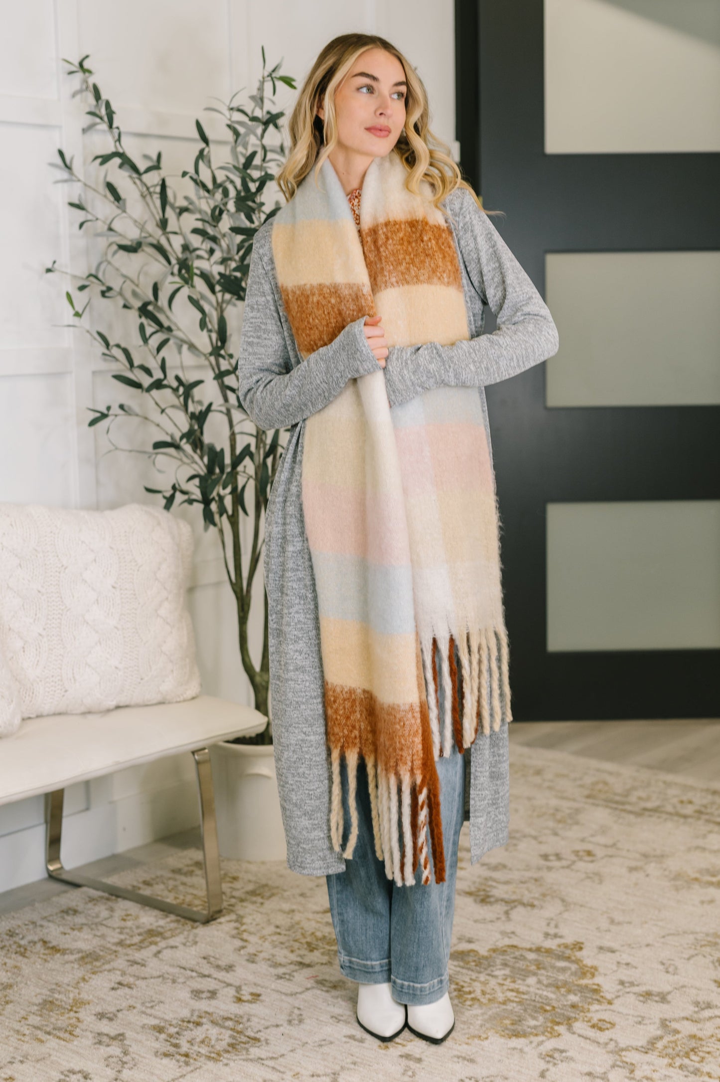 Woman wearing a long, patterned scarf in a home setting