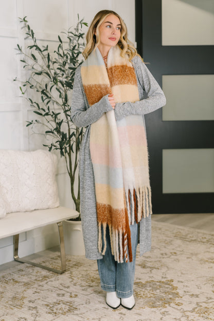Woman wearing a long, patterned scarf in a home setting