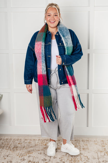 Person wearing a colorful scarf and denim jacket indoors.