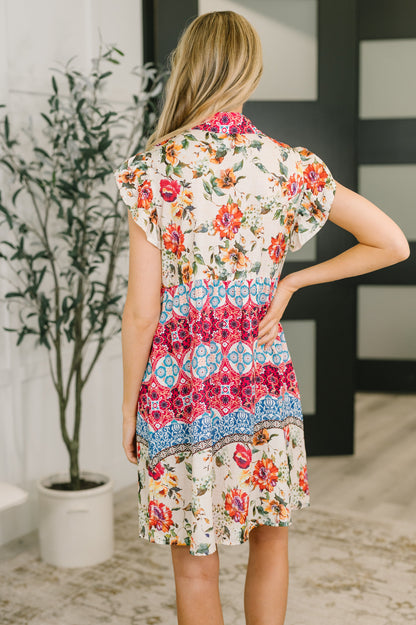 Woman wearing a colorful floral dress in an indoor setting