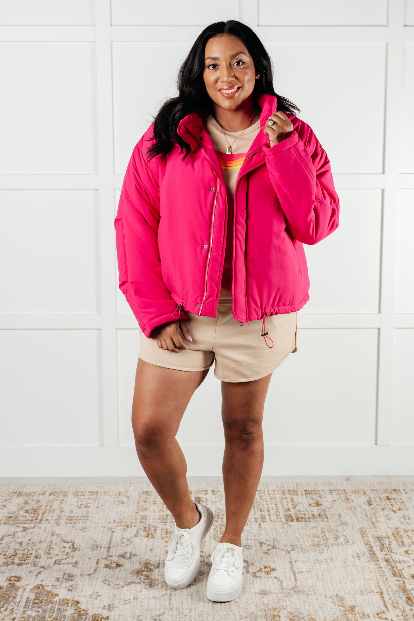 Woman wearing a bright pink jacket with a white background