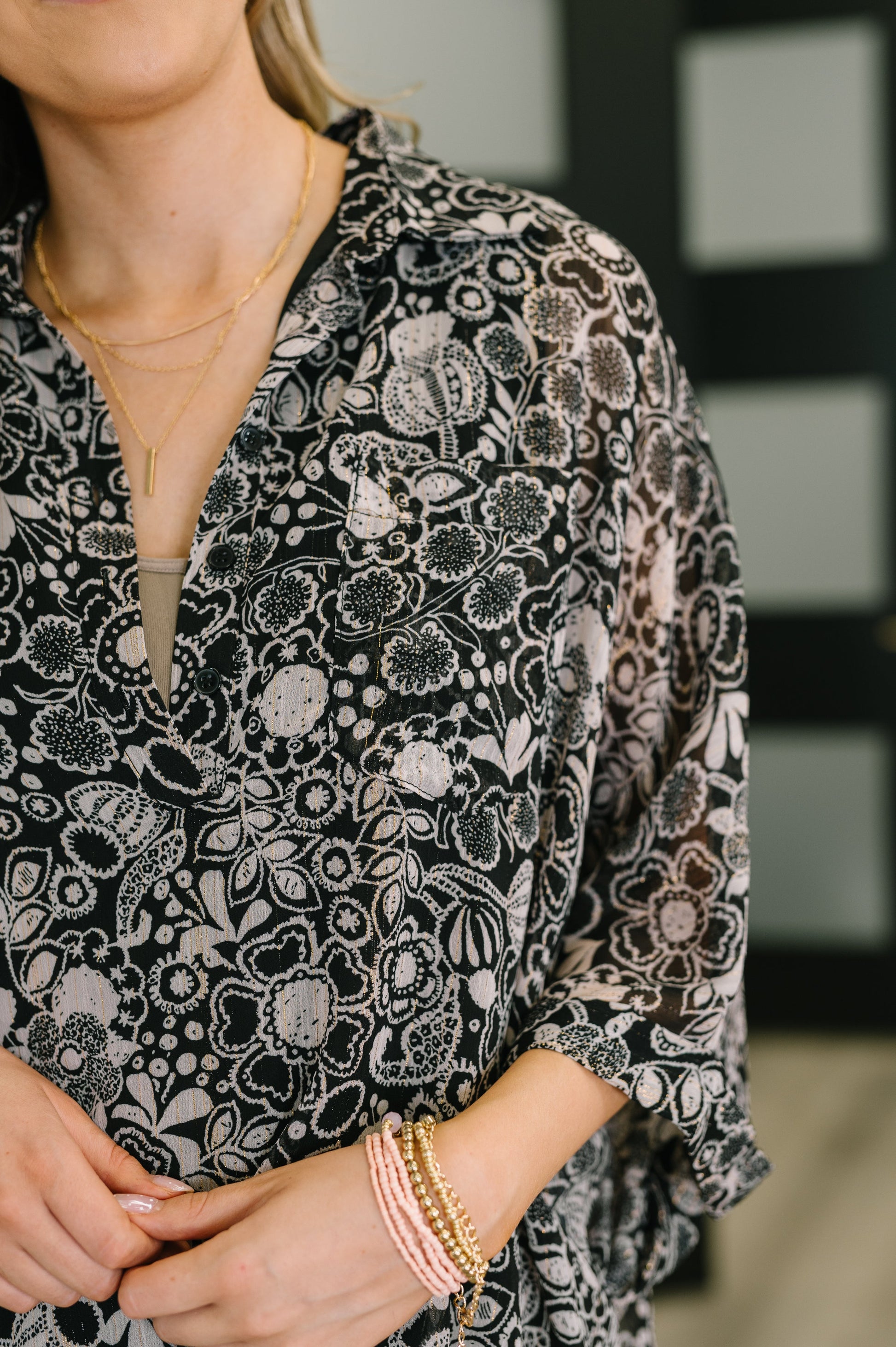 Person wearing a black floral patterned dress with a blurred background