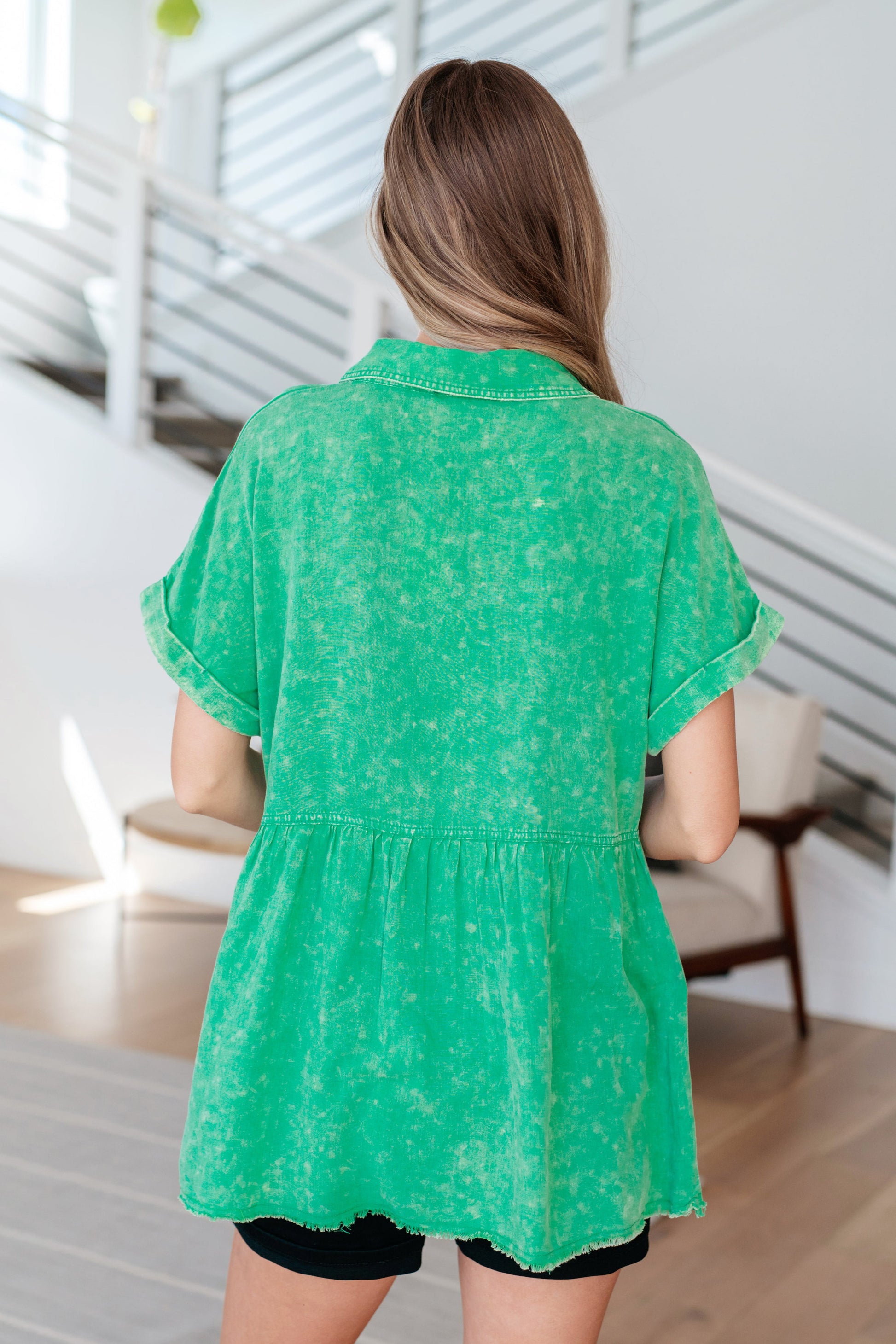 Woman wearing a green floral blouse in an indoor setting