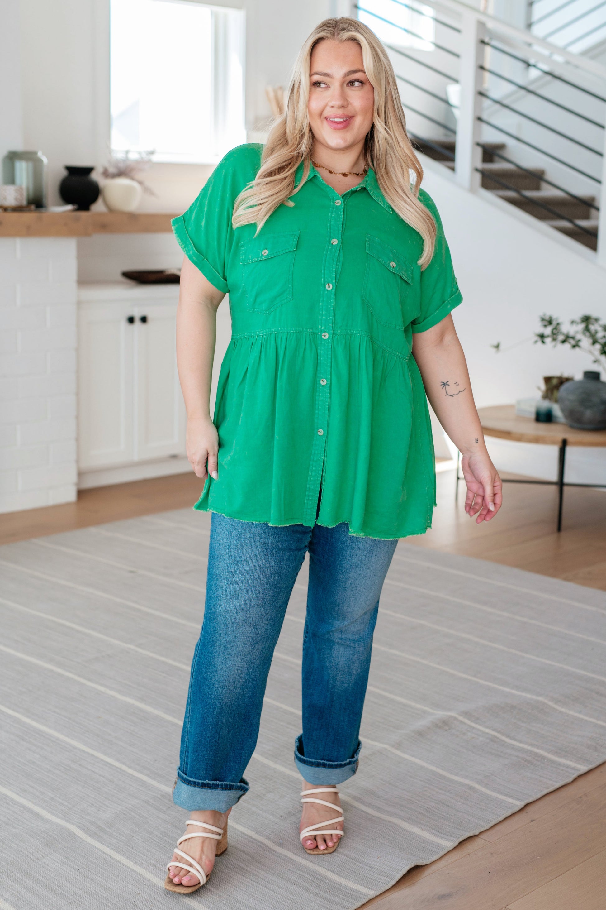 Woman wearing a green shirt and blue jeans in a kitchen setting