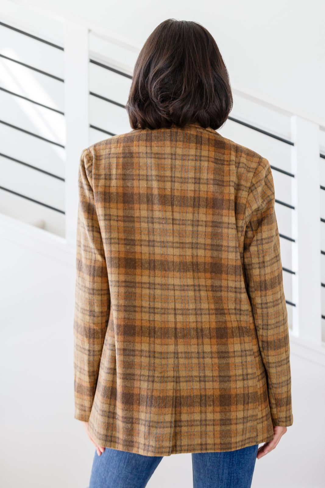 Person wearing a plaid jacket with a white background