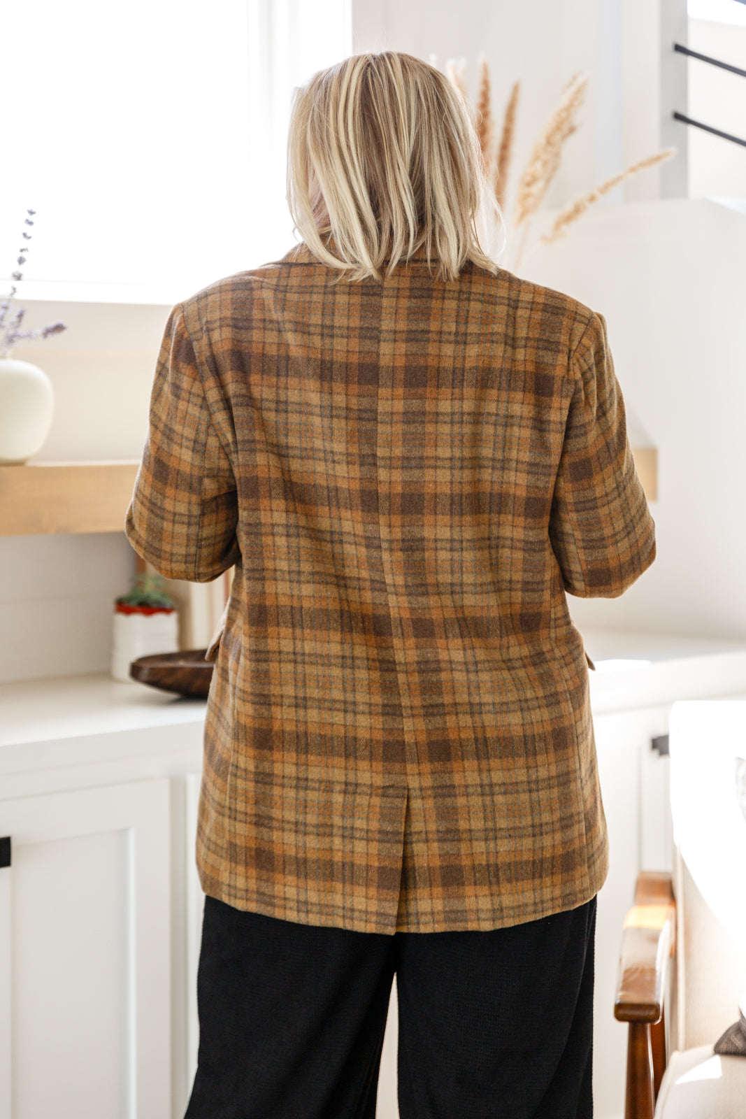 Person wearing a plaid shirt in a kitchen setting