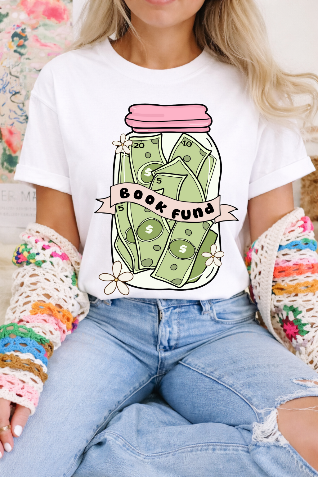 Person wearing a white t-shirt with a 'Book Fund' jar graphic design.